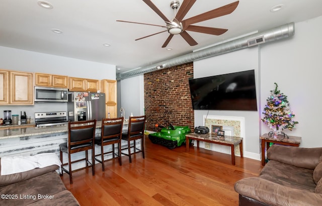 kitchen featuring appliances with stainless steel finishes, ceiling fan, hardwood / wood-style flooring, and light brown cabinets