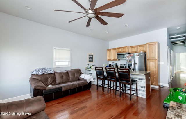 living room featuring sink, ceiling fan, and dark hardwood / wood-style floors