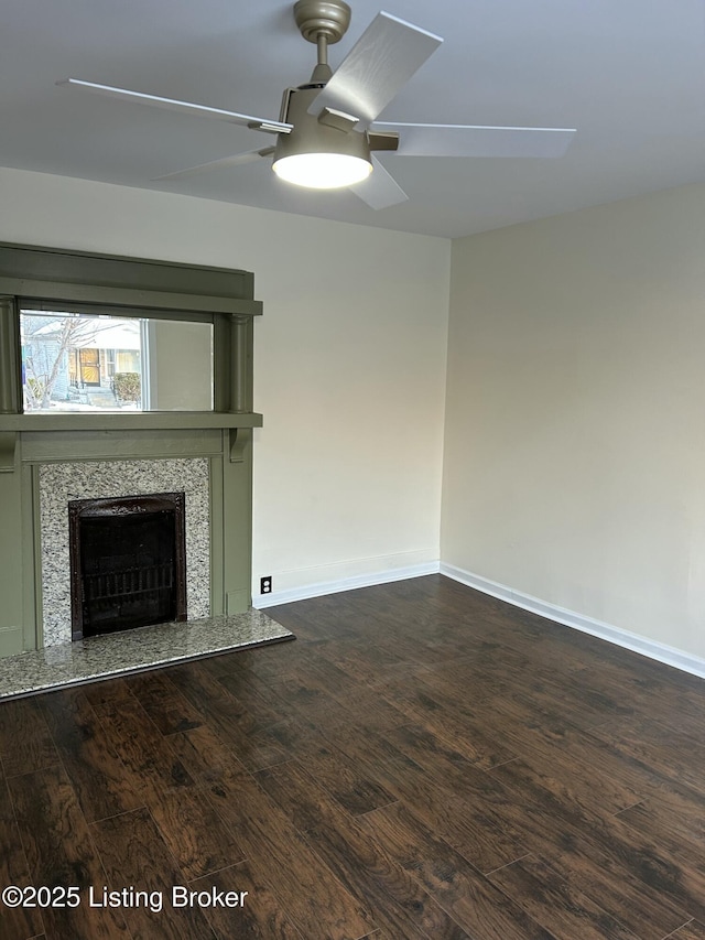 unfurnished living room featuring a fireplace, dark wood-type flooring, and ceiling fan