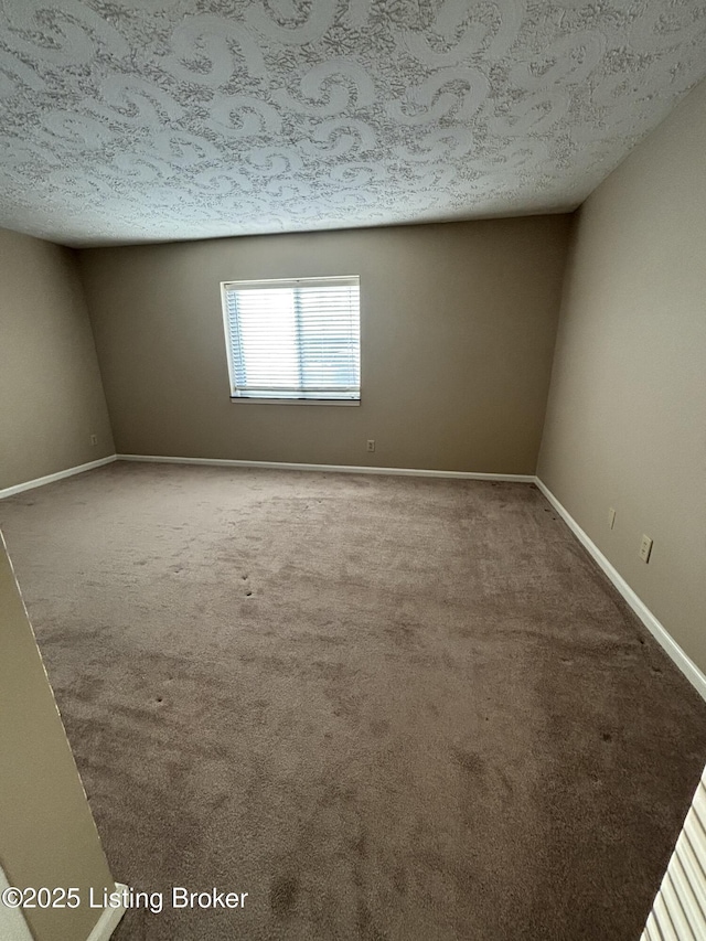 carpeted spare room with a textured ceiling