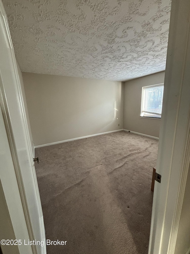 empty room featuring a textured ceiling and carpet