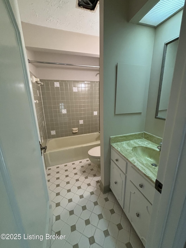 full bathroom with toilet, vanity, a skylight, and tiled shower / bath