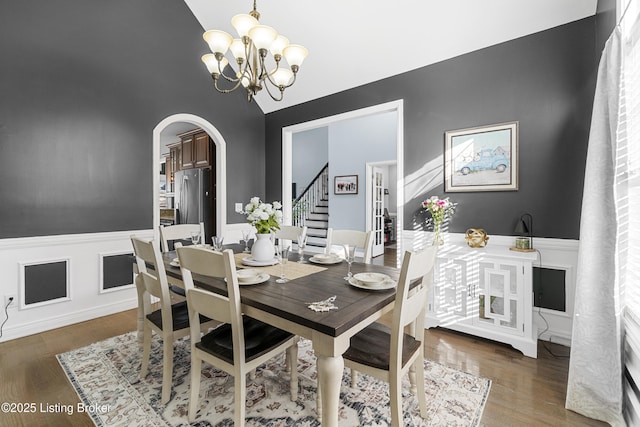 dining room featuring vaulted ceiling, an inviting chandelier, and dark hardwood / wood-style flooring