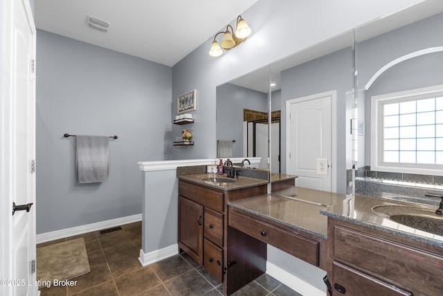 bathroom featuring tile patterned floors, a shower with shower door, and vanity