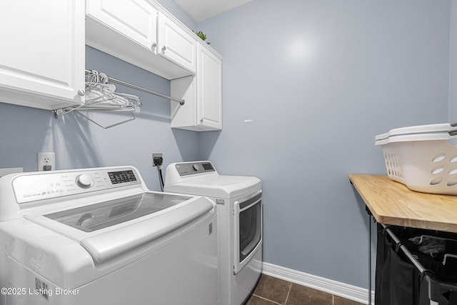 laundry room with cabinets, washer and dryer, and dark tile patterned flooring