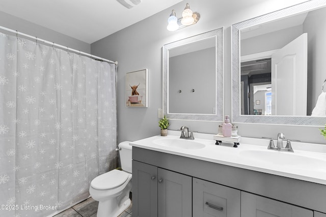 bathroom with toilet, tile patterned flooring, and vanity