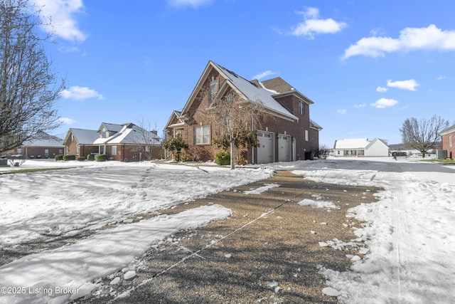 view of snowy exterior featuring a garage