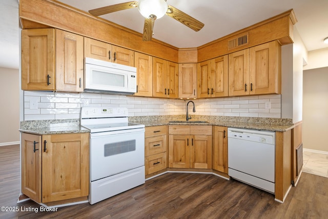 kitchen with sink, dark hardwood / wood-style flooring, ceiling fan, light stone countertops, and white appliances