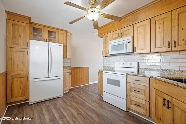 kitchen featuring dark hardwood / wood-style flooring, decorative backsplash, light stone counters, ceiling fan, and white appliances