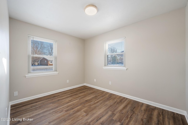 spare room featuring dark wood-type flooring and a wealth of natural light