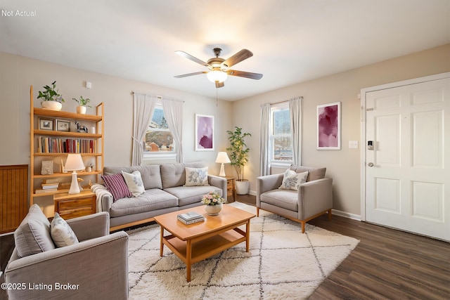 living room with a wealth of natural light, dark hardwood / wood-style floors, and ceiling fan