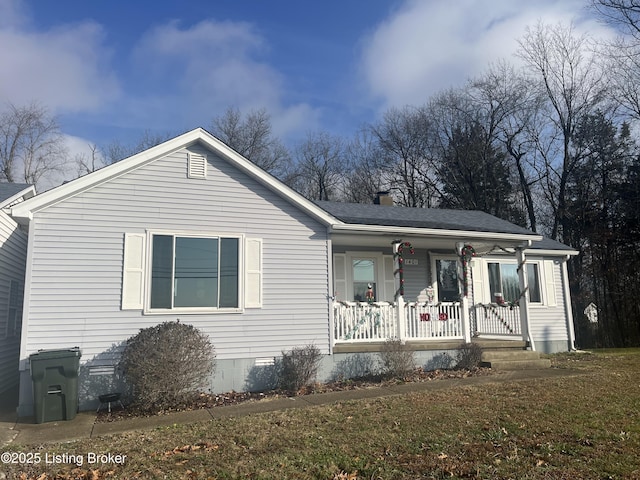 view of front facade with a front yard and covered porch