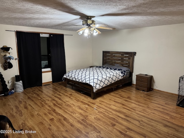 bedroom featuring ceiling fan, a textured ceiling, and hardwood / wood-style flooring