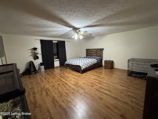 bedroom featuring a textured ceiling, ceiling fan, and wood-type flooring