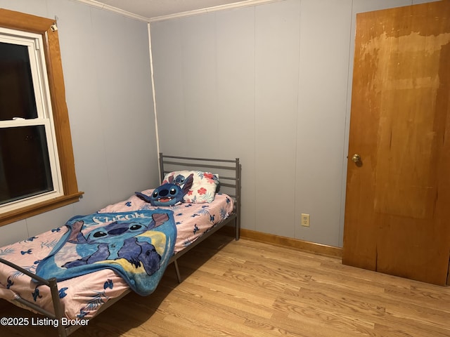 bedroom featuring light hardwood / wood-style flooring and crown molding