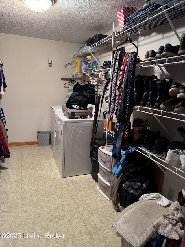 laundry area with independent washer and dryer and a textured ceiling