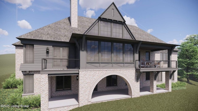 rear view of property featuring brick siding, a balcony, and a patio