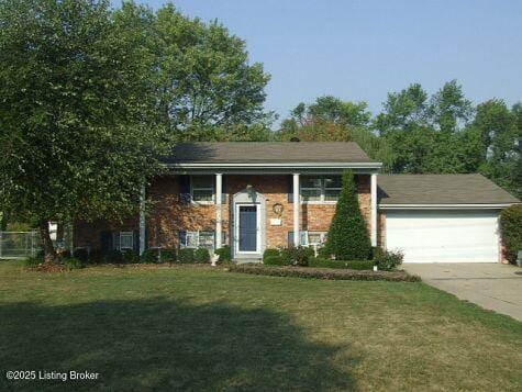 raised ranch featuring a front lawn and a garage