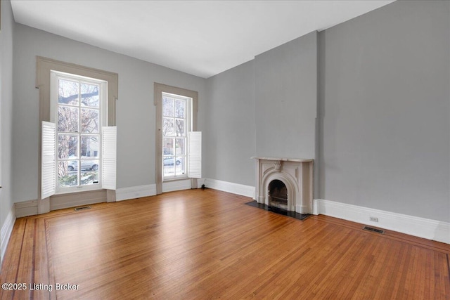 unfurnished living room with wood-type flooring and a healthy amount of sunlight