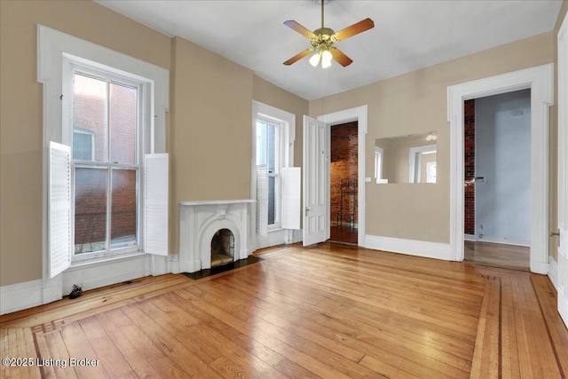 unfurnished living room featuring ceiling fan and light hardwood / wood-style flooring