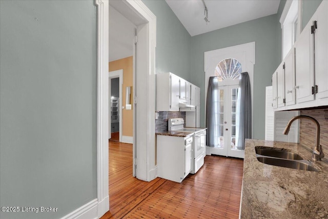 kitchen featuring dark wood-type flooring, sink, tasteful backsplash, white electric stove, and white cabinets