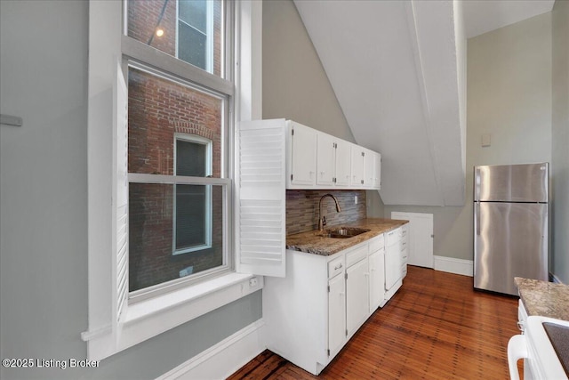 kitchen featuring sink, dark wood-type flooring, stainless steel fridge, range, and white cabinets