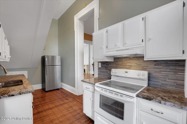 kitchen featuring sink, stainless steel fridge, dark stone counters, white range with electric stovetop, and white cabinets