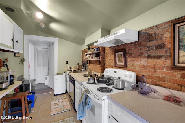 kitchen with lofted ceiling, washer / dryer, white cabinetry, white electric stove, and brick wall