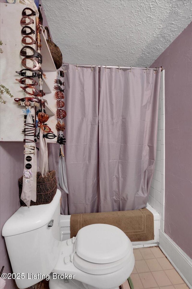 bathroom with shower / bathtub combination with curtain, a textured ceiling, and toilet