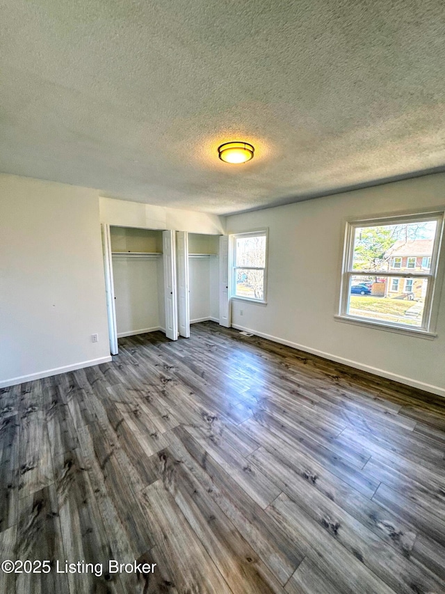 unfurnished bedroom featuring dark hardwood / wood-style flooring and a textured ceiling