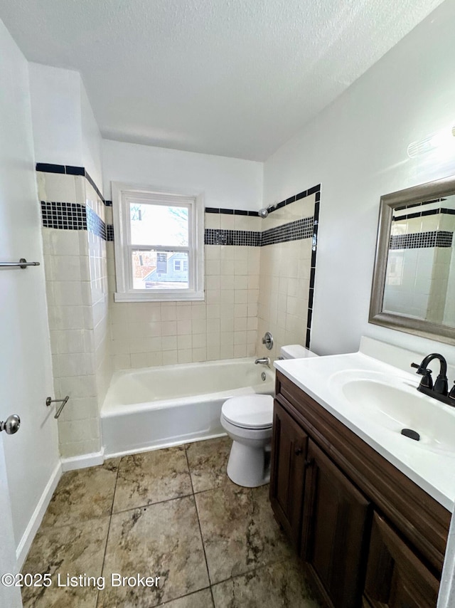 full bathroom with a textured ceiling, tiled shower / bath, tile patterned flooring, vanity, and toilet