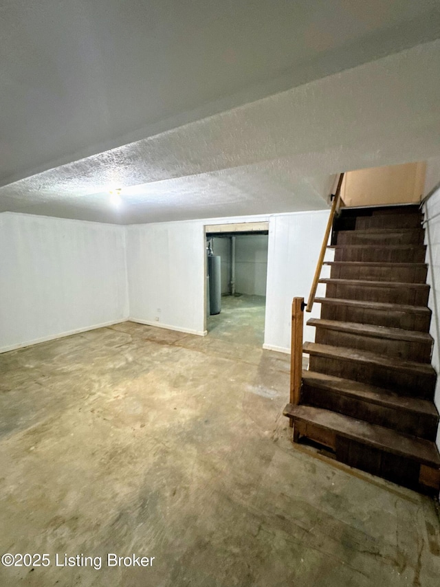 basement with a textured ceiling and gas water heater