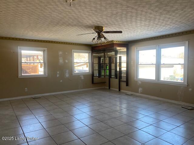 tiled spare room with ceiling fan