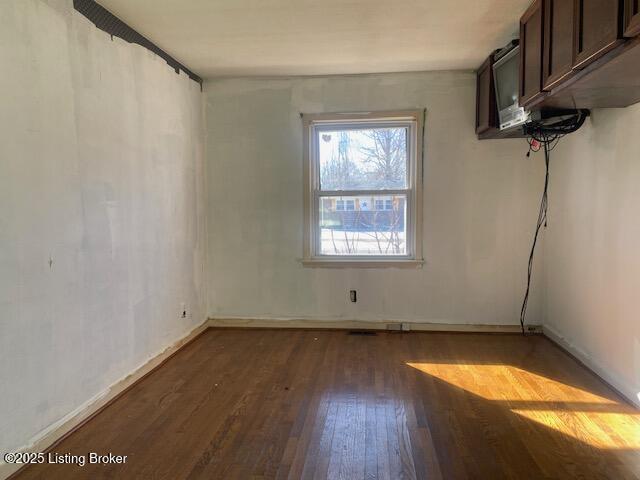 unfurnished room featuring dark hardwood / wood-style flooring