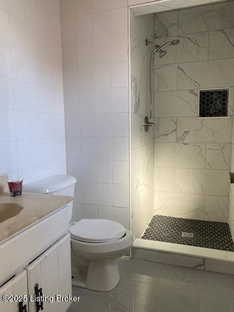 bathroom with tile walls, toilet, tiled shower, and tile patterned flooring