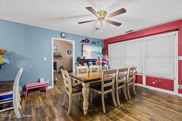 dining space featuring dark hardwood / wood-style flooring, ceiling fan, and a textured ceiling