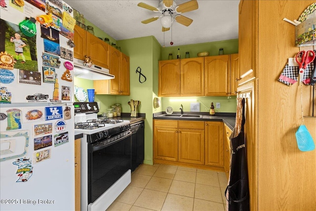 kitchen with light tile patterned flooring, range with gas cooktop, sink, white refrigerator, and ceiling fan