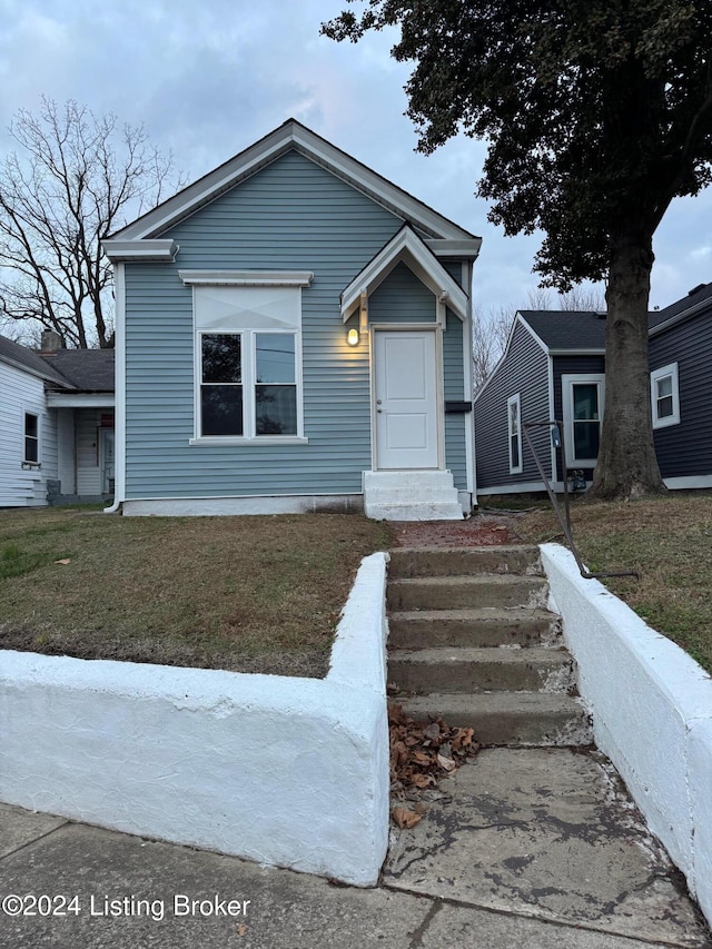 bungalow-style house featuring a front lawn