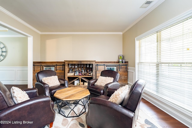 living room with crown molding, hardwood / wood-style floors, and bar area