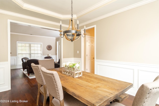 dining space with a tray ceiling, dark hardwood / wood-style floors, ornamental molding, and a chandelier