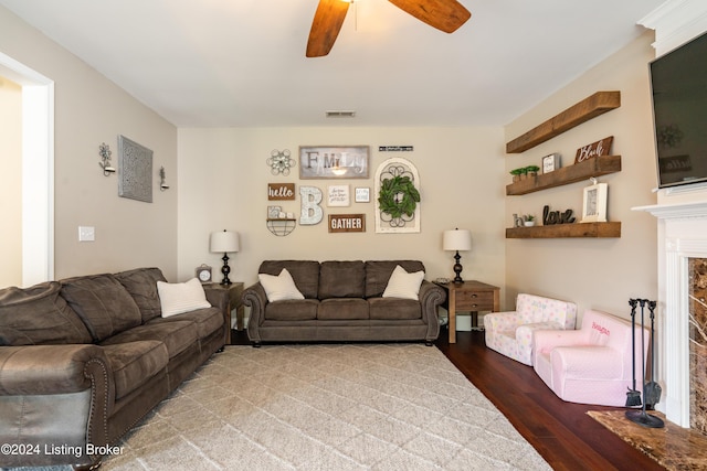 living room featuring ceiling fan and a fireplace