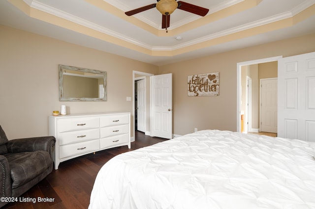 bedroom featuring ceiling fan, dark wood-type flooring, a tray ceiling, and ornamental molding