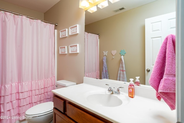 bathroom with curtained shower, toilet, and vanity