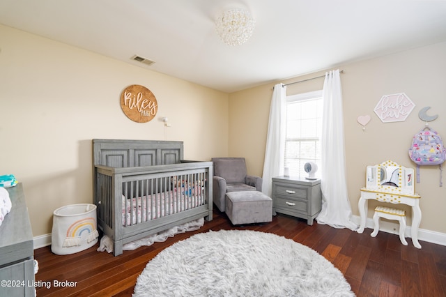 bedroom featuring dark hardwood / wood-style flooring and a nursery area