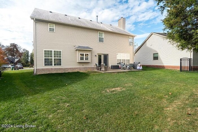 rear view of property with a yard and a patio