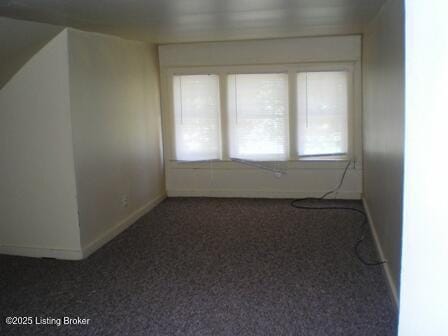 additional living space with dark carpet