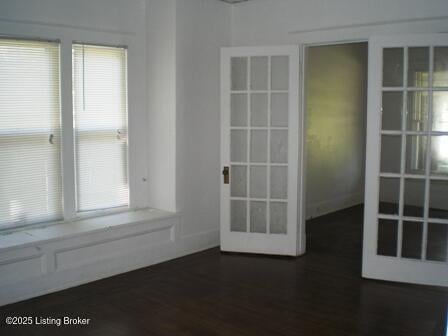 empty room featuring dark hardwood / wood-style floors and french doors