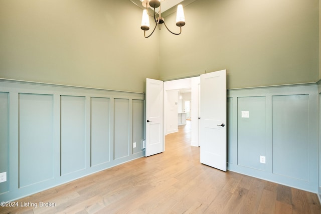 unfurnished bedroom with light hardwood / wood-style flooring and an inviting chandelier