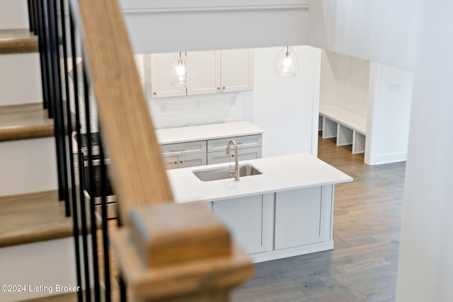 kitchen featuring decorative light fixtures, sink, tasteful backsplash, and hardwood / wood-style flooring