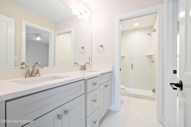 bathroom with toilet, vanity, and a shower with door